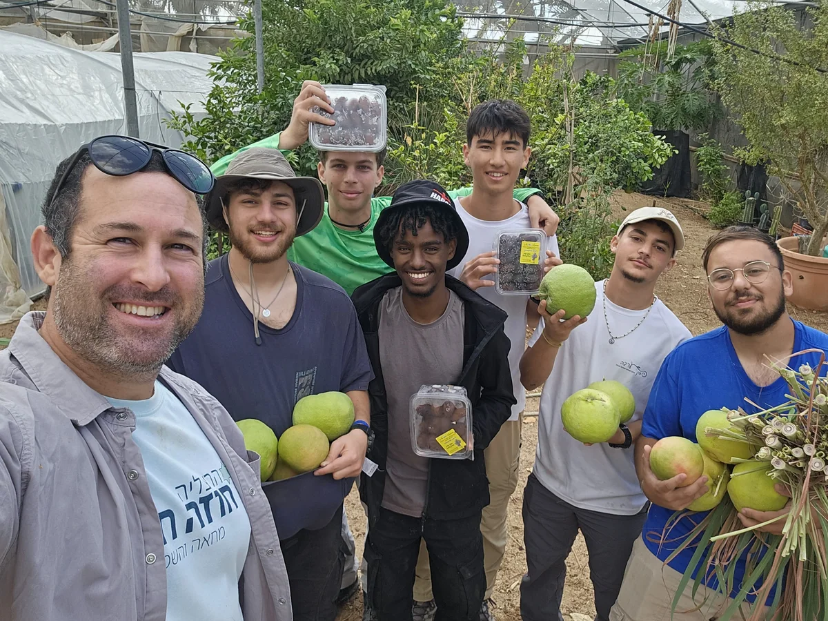 קבוצה בחממה עם פירות וקופסת תמרים