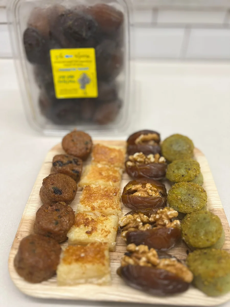 שורות של ממתקים ותמרים עם אגוזי מלך על מגש