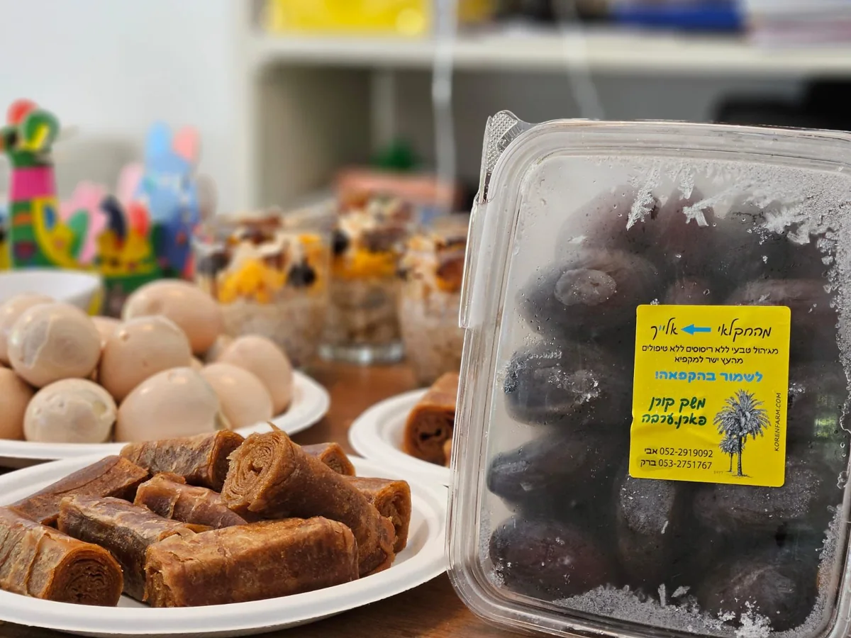 קופסת תמרים לצד מגשי מאפים וכדורים מתוקים
