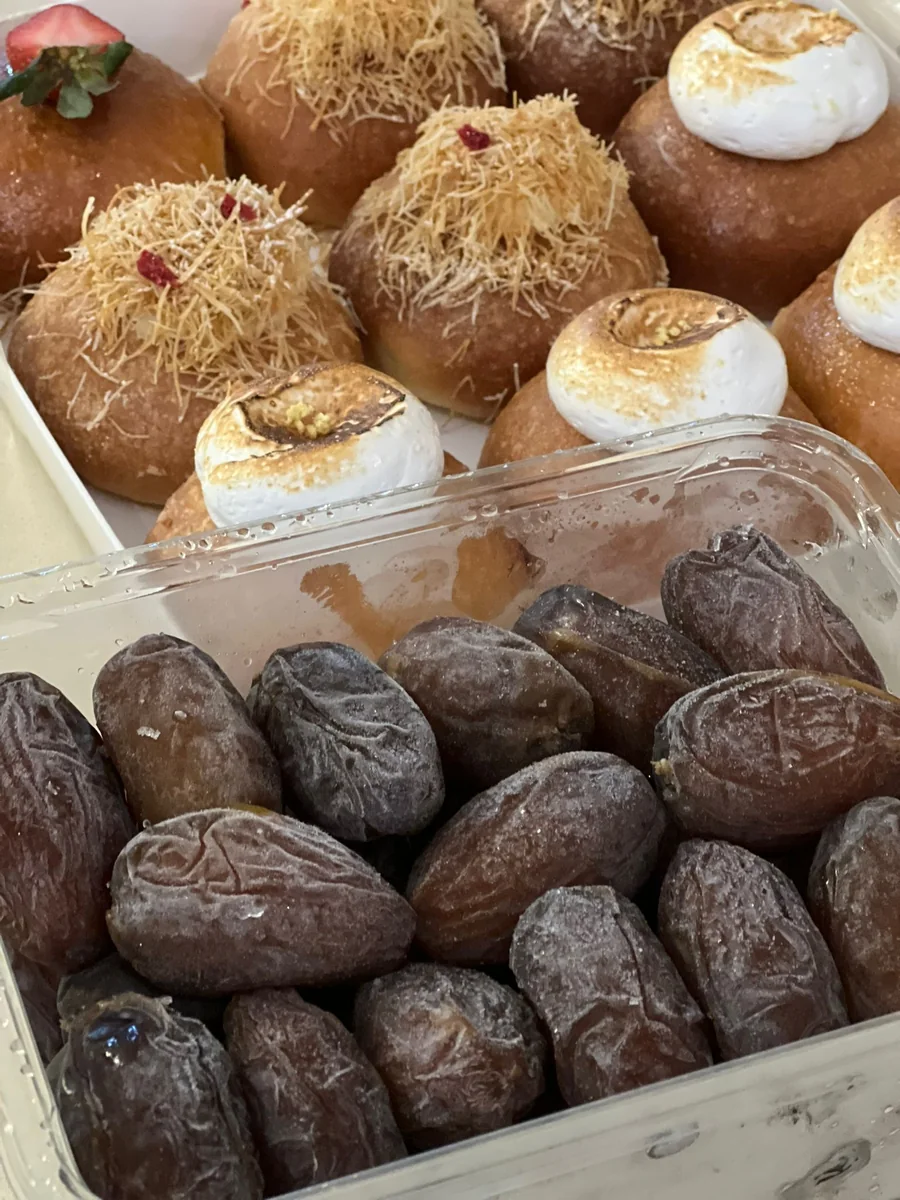 תמרים בקופסה פתוחה לצד סופגניות מעוטרות